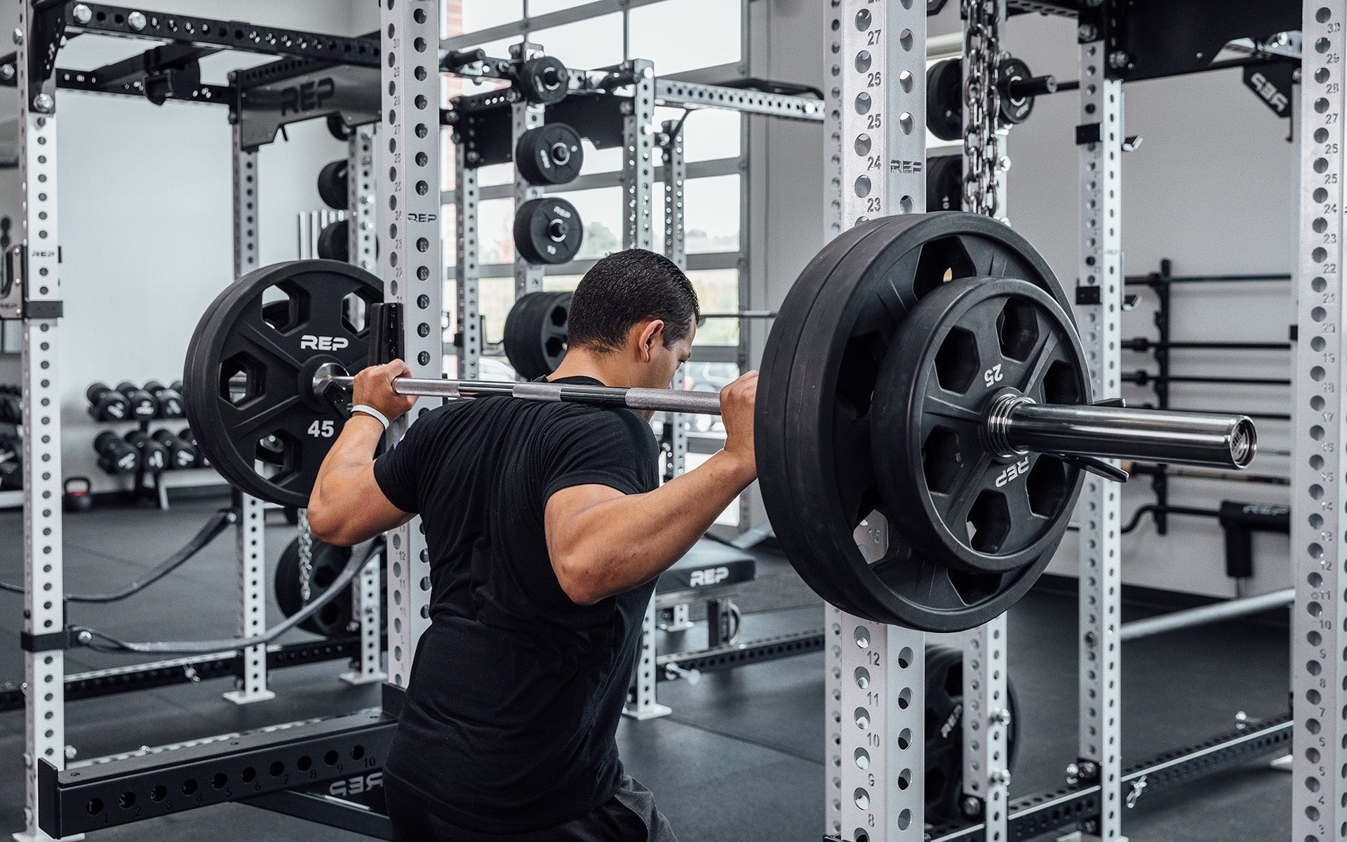 Male lifter getting ready to unrack a loaded REP Delta Basic Bar to perform a back squat.